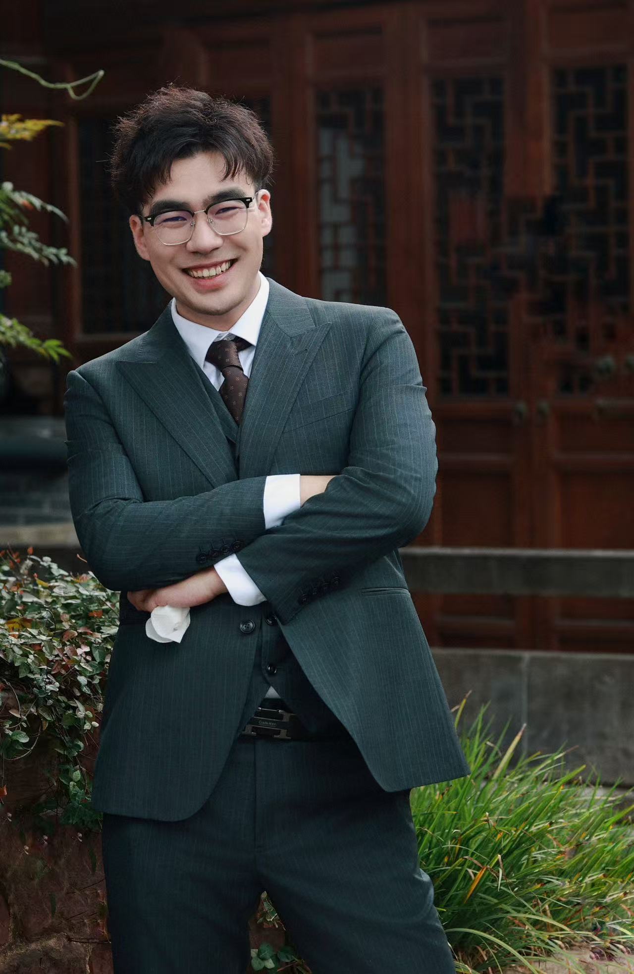 董剑铭身穿深绿色西装、佩戴眼镜并微笑的肖像